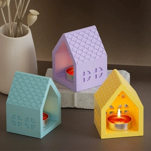 Detailed view of colorful ceramic house candle holders with decorative scale roofs and windows