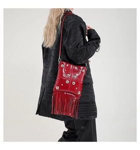 Detail view of red rivet shoulder bag with long fringes and polished silver studs