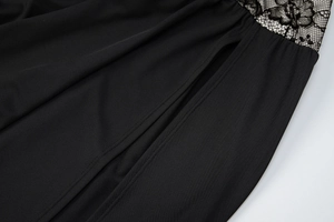 Détail des coutures en dentelle noire et de la fente élégante sur la robe moulante