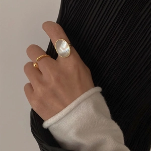 Macro view of vintage oval mother of pearl gold ring with adjustable open band detail