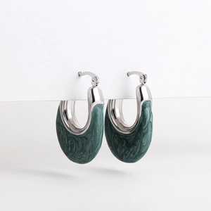 Detailed macro view of U-shaped earrings with green marble enamel and silver finish