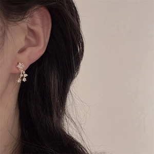 Detailed close-up of vintage gold star earrings with pink stones and pearl tassels