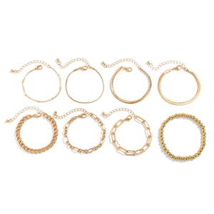 Set of eight gold bead and link bracelets featuring heart pendants in a studio close-up