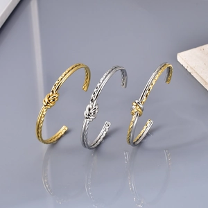 Minimalist knot cuff bracelet in gold and silver finish with elegant twisted bow design