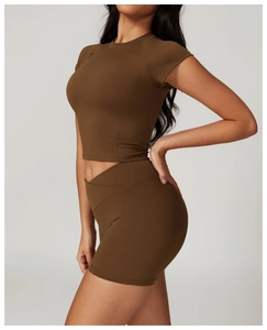 Detail of high-stretch recycled fabric and flat seams on brown yoga crop top and shorts