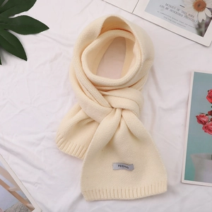 Detail of beige ribbed knit scarf texture with FEIDING brand tag on soft fabric