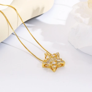 Close-up of 18k gold plated star pendant with sparkling cubic zirconia on a delicate chain