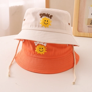 Détail de chapeaux bobs pour enfants en coton avec sourire jaune et cordon coupe-vent
