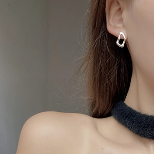 Close-up of irregular hollow geometric S925 sterling silver earring on a model