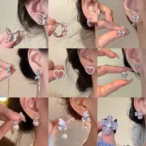 Collage de boucles d'oreilles variées avec motifs papillon, cœur et perle en argent
