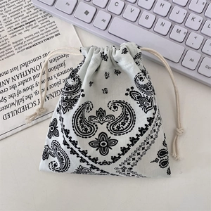 Detail of paisley print drawstring storage bag on desk with keyboard and newsprint