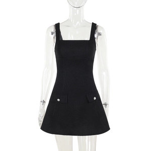 Close-up of black tweed sleeveless dress featuring textured fabric and white pearl buttons