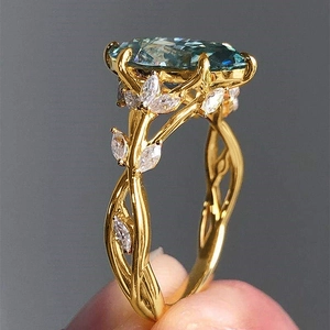 Macro shot of luxury gold ring with oval blue gemstone and marquise diamond leaves