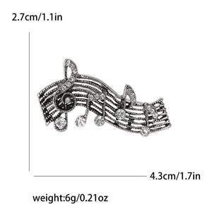 Detail showing musical note brooch dimensions 2.7x4.3cm with weight 6g in silver tone