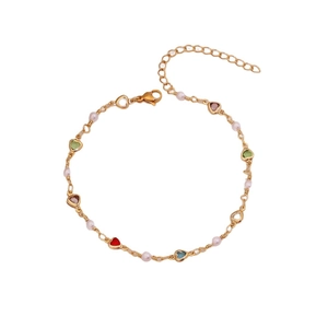 Fashionable gold anklet with colorful heart crystals and white pearls on white background