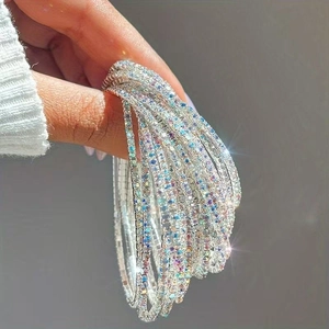 Close-up of flexible multi-row silver crystal bracelet with sparkling rhinestones for women
