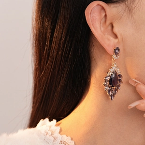 Vintage zircon flower earrings with purple teardrop crystal on model closeup