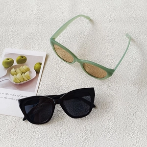 Stylish small frame retro sunglasses in green and black colors on a fresh spring background