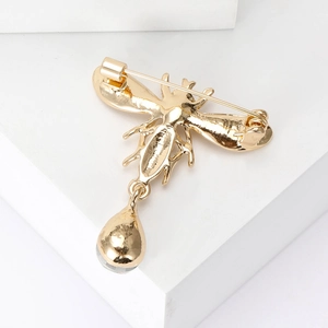 Creative gold bee brooch with teardrop pendant in a minimalist metallic animal design