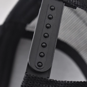 Detail view of the adjustable black snapback closure and breathable mesh on a baseball cap