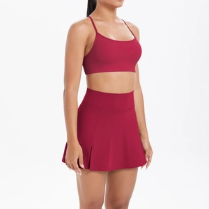 Détail d'un ensemble de sport bordeaux avec brassière à fines brides et jupe plissée