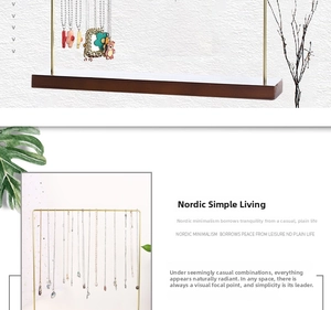 Nordic jewelry stand detail with gold metal frame and dark solid wood base for necklaces