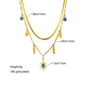 Detail of double-layer 18K gold plated necklace with turquoise eye and lightning charms