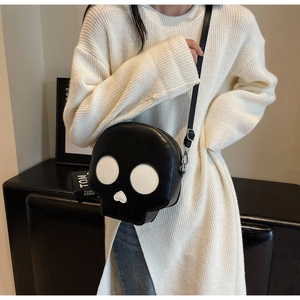 Detail view of funny skull crossbody bag with heart-shaped nose on white knit sweater