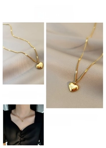 Detailed view of a gold heart pendant with Love engraving on a mixed style chain