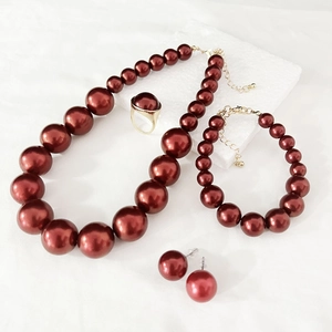 Elegant deep red pearl jewelry set with necklace, bracelet, earrings and gold ring