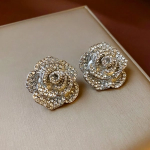 Macro shot of silver rose flower earrings encrusted with sparkling crystals for women