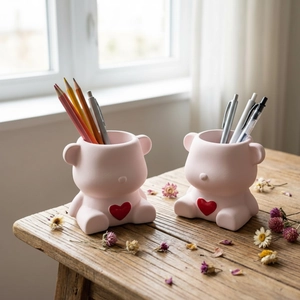 Lot de moules en résine porte-stylo ours rose avec cœur rouge sur bureau en bois