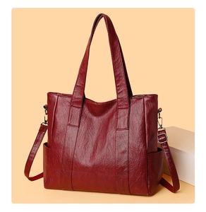 Detail of wine red PU leather tote bag showing side pockets and smooth texture