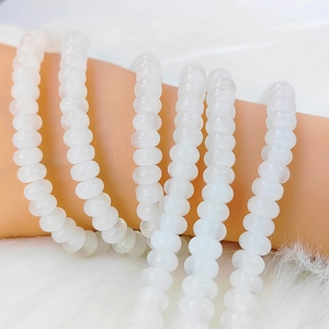 Macro detail of creamy white translucent abacus beads bracelets on a plush background