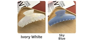 Detail of large acetate hair claws in pearly white and ink blue with gold accents