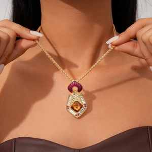 Gros plan détaillé d'un pendentif ambre vintage avec zircons sur chaîne dorée