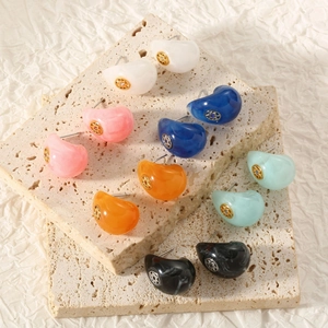 Detailed view of colorful C-shaped resin earrings with gold hollowed floral patterns