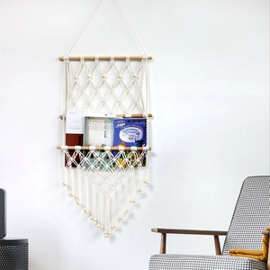 Detail of bohemian three-tier woven cotton rope wall shelf with tassels and wooden beads