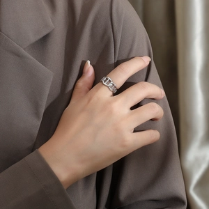 Close-up of polished silver chain link ring worn on finger for professional business attire