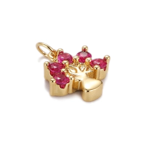 Detailed view of 18K gold tree pendant with red zircon stones on a white background