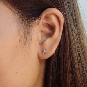 Gros plan de boucles d'oreilles triangle minimalistes avec trois zircons cubiques clairs