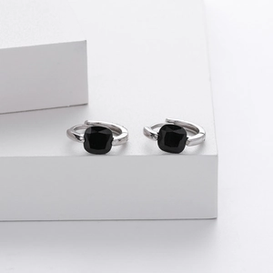 Close-up of S925 silver hoop earrings with square black zircon stones on white background