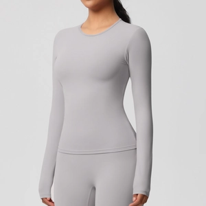 Détail du haut de sport à manches longues gris clair montrant la coupe slim et le tissu