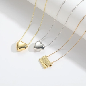 Set of four vintage necklaces featuring gold and silver heart and envelope pendants