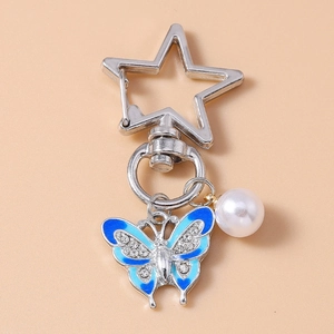 Detail of silver star clasp with blue rhinestone butterfly and white pearl charm