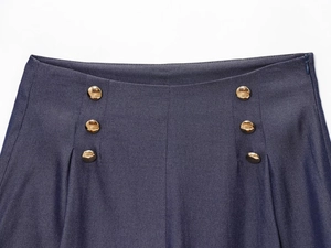 Détail du pantalon en lin bleu marine à taille haute, boutons dorés et fermeture invisible