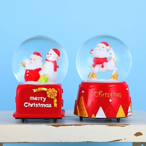 Rotating Christmas snow globe with Santa and snowman on red base for holiday decor