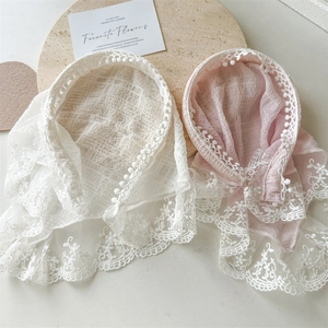 Close-up of textured seersucker lace bandanas with pom-pom trim in pink and white