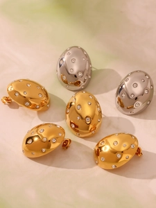 Macro shot of oval 18k gold and silver plated stud earrings with Czech rhinestones