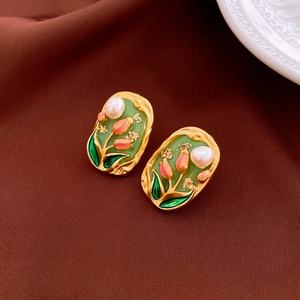Detail of vintage tulip earrings with pink enamel, gold plating, and a pearl accent